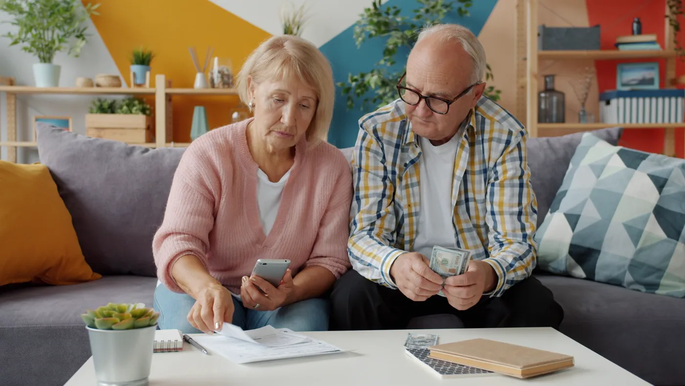 An older couple at home going through their bills together